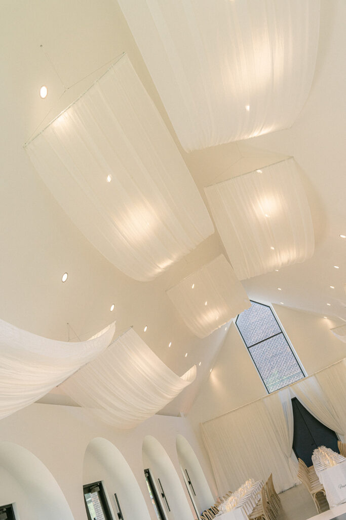 Dramatic drapery hanging from the ceiling in wedding reception space at The Lumen House
